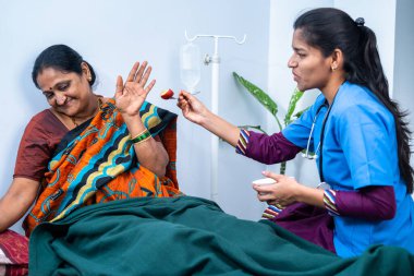 Hasta orta yaşlı hasta bakım evindeki bakım hemşiresinin meyvelerini yemeyi reddediyor. Bakım, asistan ve mesleki meslek anlayışı..