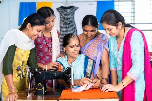 group of woman at tailoring class discuissing with teacher about cloth and stitching during training - concept of skill development and vocational training.