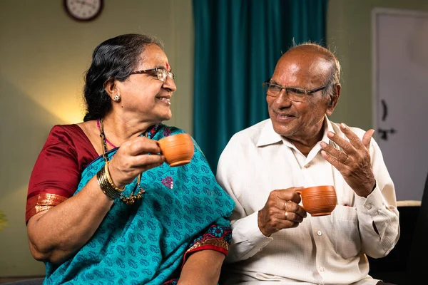 快乐的老夫妇一边喝茶一边在家里聊天 团聚和退休生活方式的概念 — 图库照片
