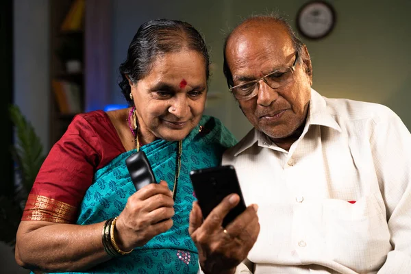 Happy Smiling Senior Couple Using Mobile Phone Wife Holding Remote — Stockfoto