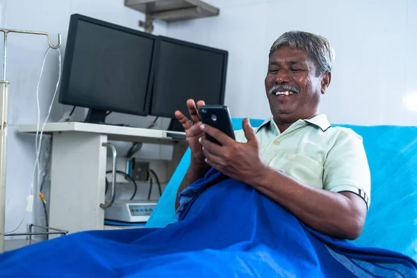 Щасливий Усміхнений Старший Чоловік Використовуючи Мобільний Телефон Лікарні Лежачи Ліжку — стокове фото