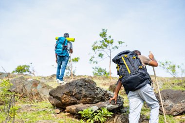 Tepeye ya da dağa tırmanan orta yaşlı yürüyüşçülerin arka plan görüntüsü - macera, boş zaman aktiviteleri ve yürüyüş kavramı