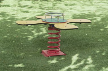 Yapay yeşil bir çayırda oyun parkında rockçı yayı