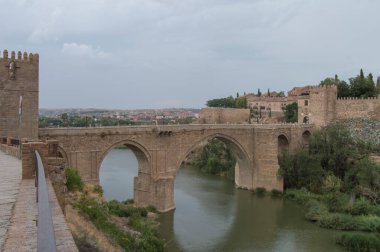 Toledo 'da gün batımında San Martin Köprüsü manzarası. İspanya