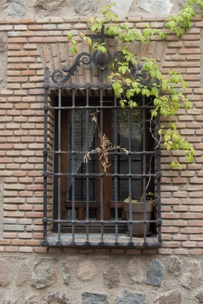 Pared Ladrillo Piedra Con Una Ventana Rallada Con Hojas Verdes —  Fotos de Stock