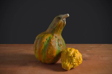 Koyu arkaplanda iki sarı balkabağı