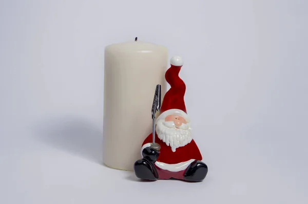 Pequena Cerâmica Papai Noel Lado Uma Vela Branca Isolado Fundo — Fotografia de Stock