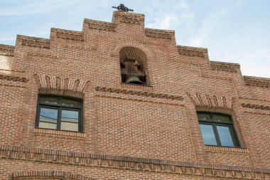 İki pencereli tuğla cephe ve Madrid 'de dini bir binada çan çalan bir boğa. İspanya