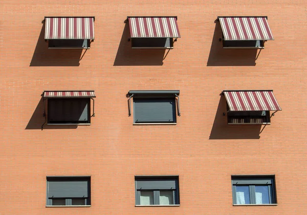 Genişletilmiş tenteli kare pencereli tuğla cephe