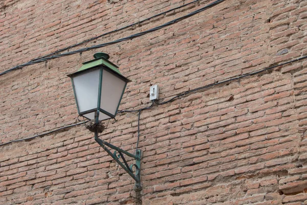 lantern on a brick wall in a street in Alcal de Henares, province of Madrid. Spain