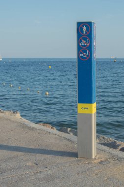 Vertical post with three prohibition signs on the coast of Barcelona. The word amb in Catalan means with