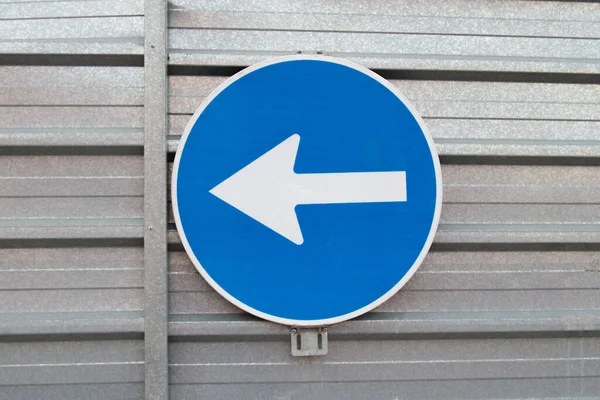 traffic sign with arrow indicating left on a metal panel