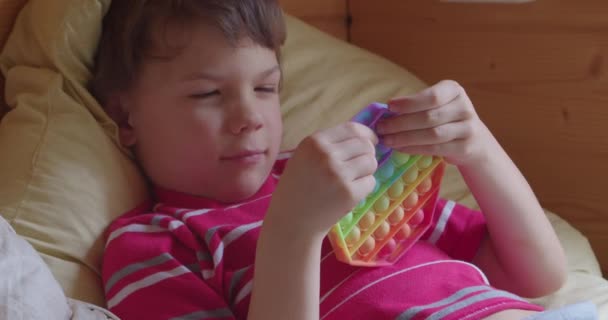 Gyermek fiú a Pop It játék fidget — Stock videók