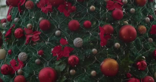 Sapin de Noël décorant boules rouges et des arcs avec la neige tombante. contexte — Video