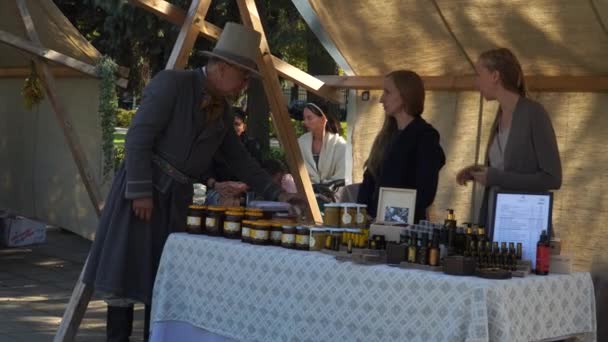 ラトビアのリガ 2021年8月22日 通りの市場で蜂蜜製品の若い女性の販売 伝統的な自家製食品市場の人々や売り手との夏のシーン — ストック動画
