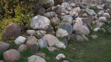 Ortaçağ şatosu taşları ve manzaralı antik bir duvar parçasını harabeye çeviriyor. Dobele kalesi Letonya, Avrupa 'daki tarihi toprakları harap ediyor. 2022 Ekim 'inde sonbaharda mimari manzara.