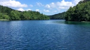 Hırvatistan 'daki Plitvice Gölü' nün panoramik manzarası yaz güneşli bir günde yüzen bir feribottan.