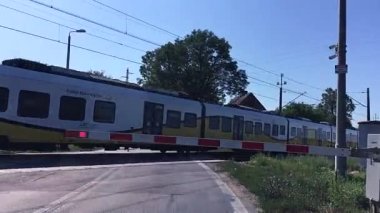 Demiryolu seviyesi geçiş sinyalleri bariyer demiryolunun arkasında yanıp sönen kırmızı ışıklar. Tren geliyor..