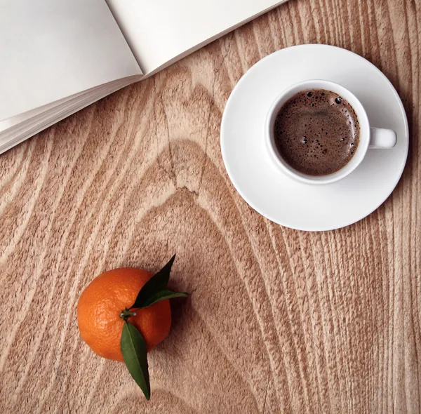 Taza de café oscuro, mandarina, libro abierto —  Fotos de Stock