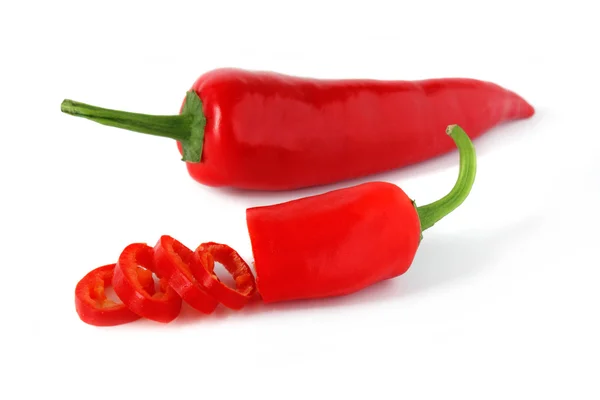 Sliced red chili pepper and one whole on white — Stock Photo, Image