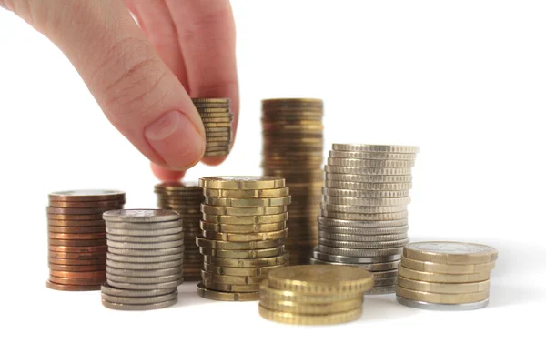 Montones de monedas y mano aislada en blanco — Foto de Stock