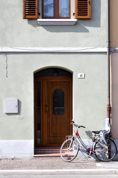 Vägg med trä dörr, fönster och cykel — Stockfoto