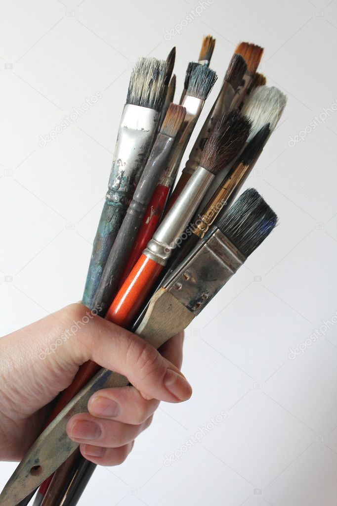 Bunch of stained brushes in woman hand