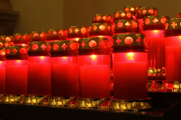 Velas vermelhas acesas dentro de uma igreja — Fotografia de Stock