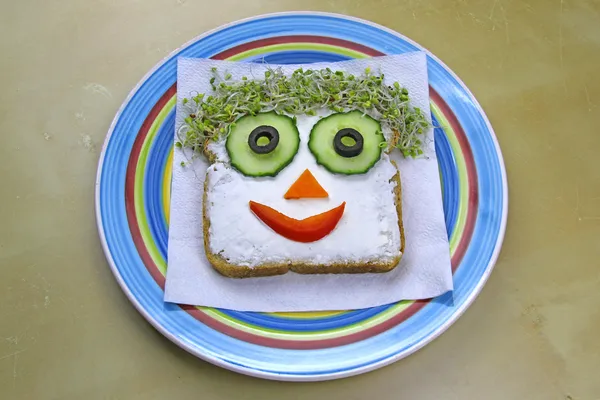 Веселый сэндвич в форме лица для детей на тарелке — стоковое фото