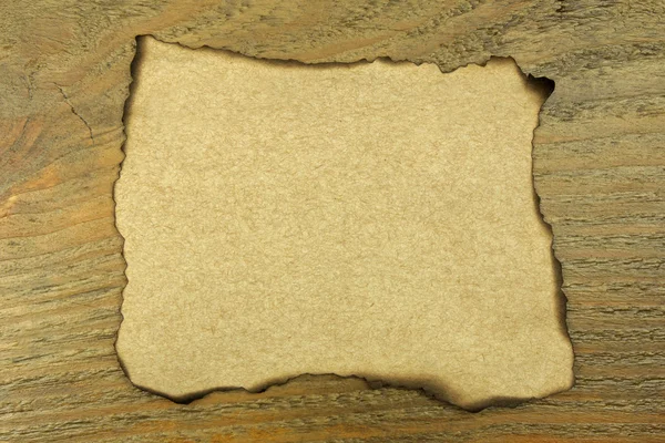 Burnt paper on old wood background — Stock Photo, Image