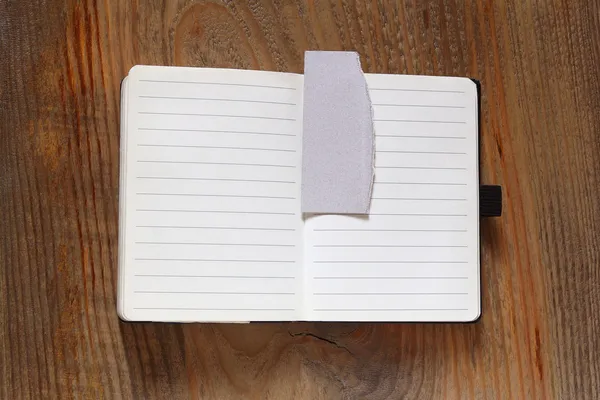 Caderno com dobra na mesa de madeira — Fotografia de Stock