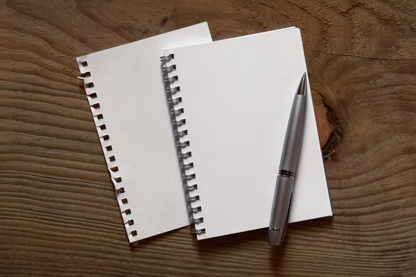 スパイラル ノートと木製の机の上のペン — ストック写真
