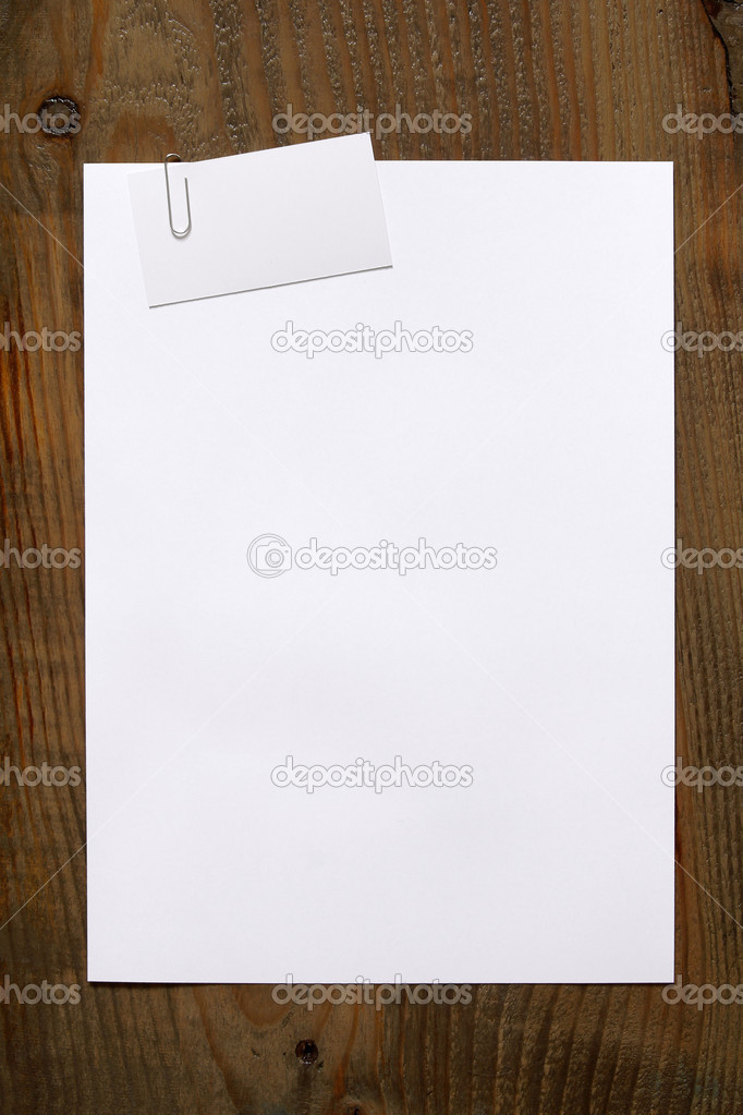 Blank white paper and business card clipped a paperclip on woode