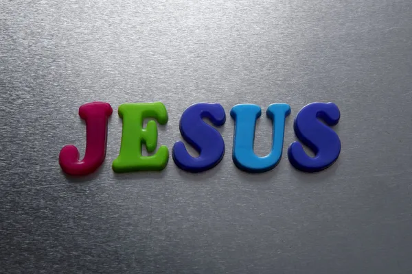 Jesus word spelled out using colored fridge magnets — Stock Photo, Image