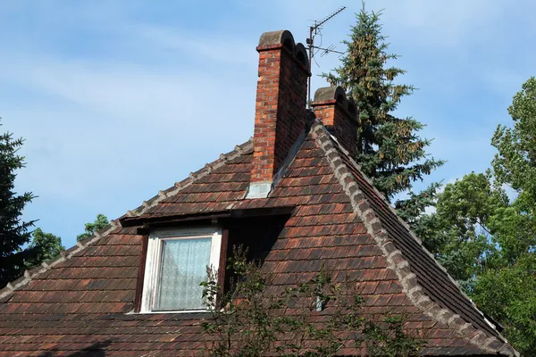 Techo de teja de casa antigua con dos chimenea y ventana —  Fotos de Stock
