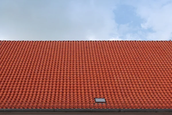 Rött kakel taket mot blå himmel — Stockfoto