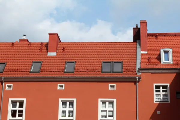 Rotes Gebäude mit Ziegeldach gegen blauen Himmel — Stockfoto