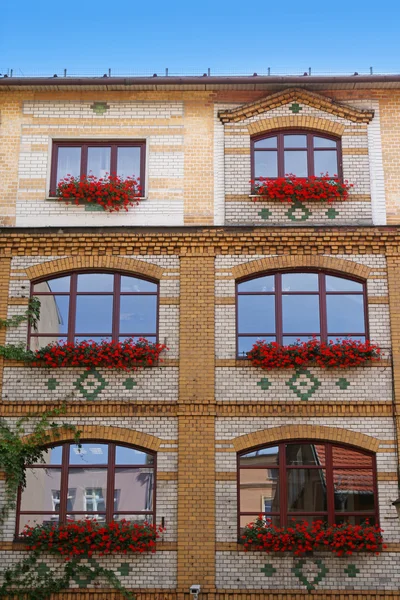 Facade of beautiful building with flowerpots — Stock Photo, Image