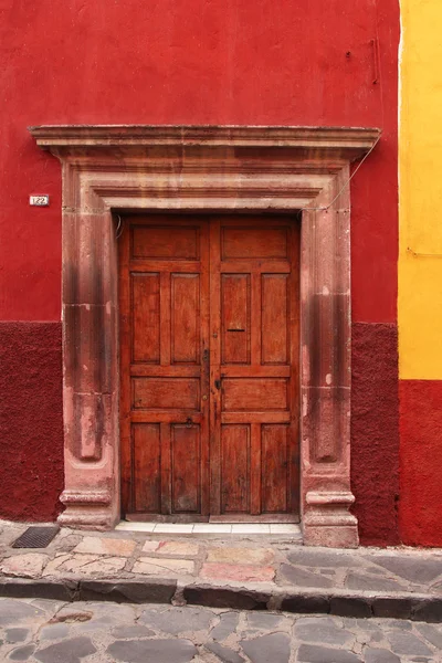 Porta in legno a muro rosso. architettura tipica messicana — Foto Stock