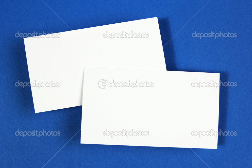 Two blank business cards on blue paper background