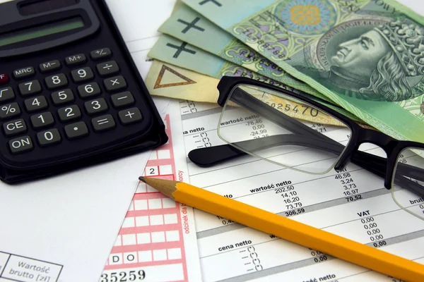 Miniräknare, glasögon, penna och polska pengar sedlar på räkningar — Stockfoto