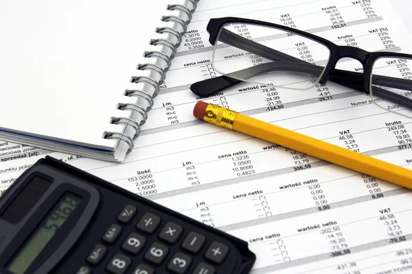 Glasses, calculator, pencil and paper bills — Stock Photo, Image