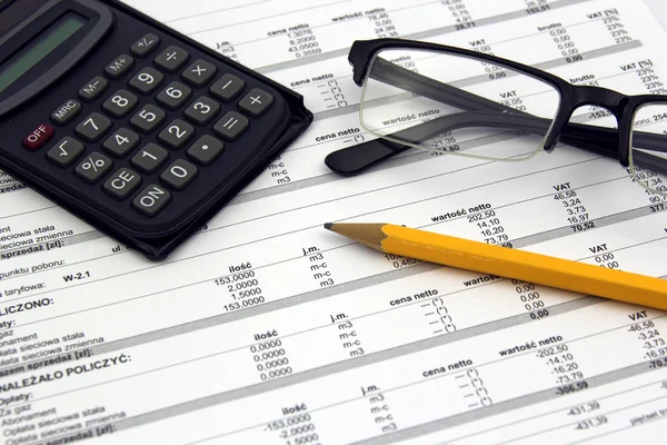 Glasses, calculator and pencil on paper bills — Stock Photo, Image