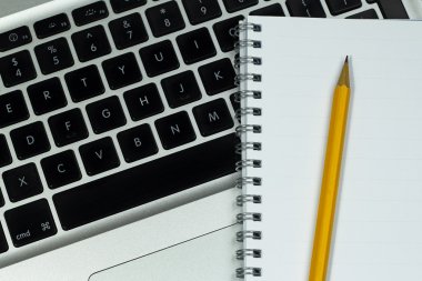 laptop ve boş defter kalem ile