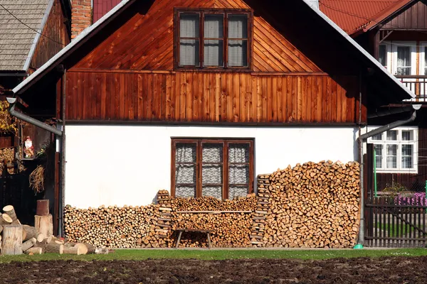 Casa de madera con montón de troncos de madera listo para el invierno —  Fotos de Stock