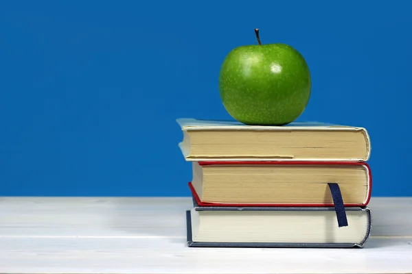 Green apple on pile of books — Stock Photo, Image