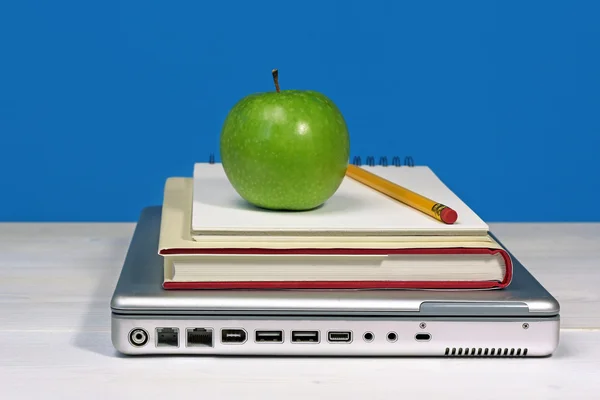 Grönt äpple, penna och bokar på laptop — Stockfoto