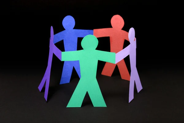 Círculo de pessoas de papel colorido no fundo preto — Fotografia de Stock