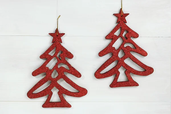 白い木製の背景に 2 つの光沢のある赤いクリスマス ツリー — ストック写真
