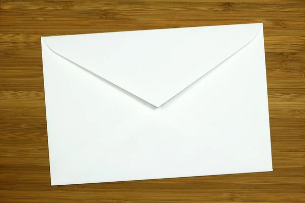 Envelope branco no fundo de madeira — Fotografia de Stock